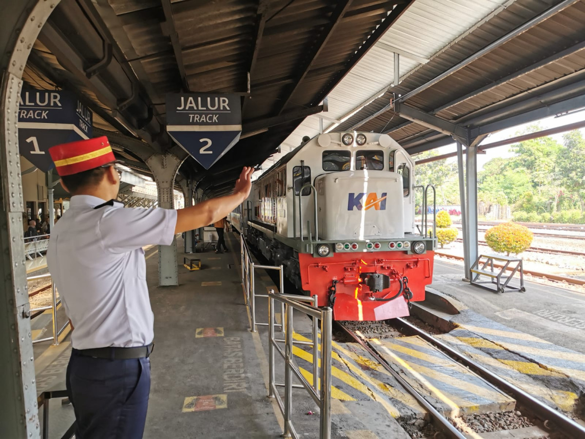 Petugas Stasiun memberangkatkam kereta api (foto: istimewa)