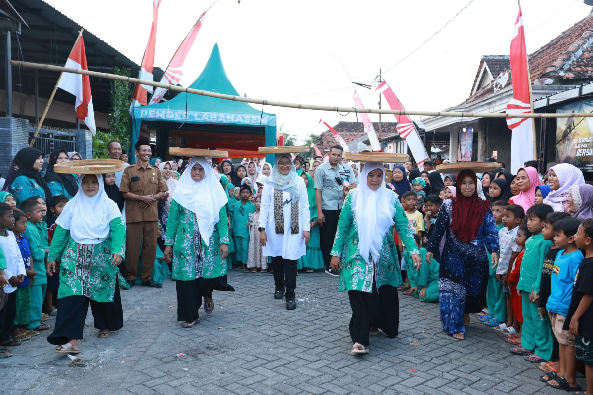 Bupati Banyuwangi Ipuk Fiestiandani mengikuti lomba nyunggi tampah di Desa Labanasem, Kecamatan Kabat (foto : istimewa)