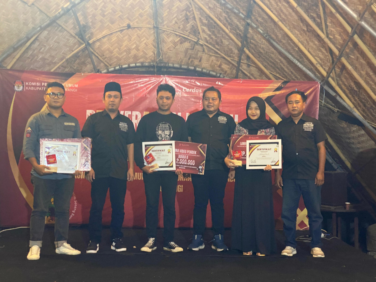 Komisioner KPU Kabupaten Banyuwangi Divisi Sosdiklih, Parmas dan SDM, Enot Sugiharto bersama Ketua IJTI Banyuwangi, Syamsul Arifin memberikan hadiah kepada tiga pemenang lomba video kreatif Pilkada