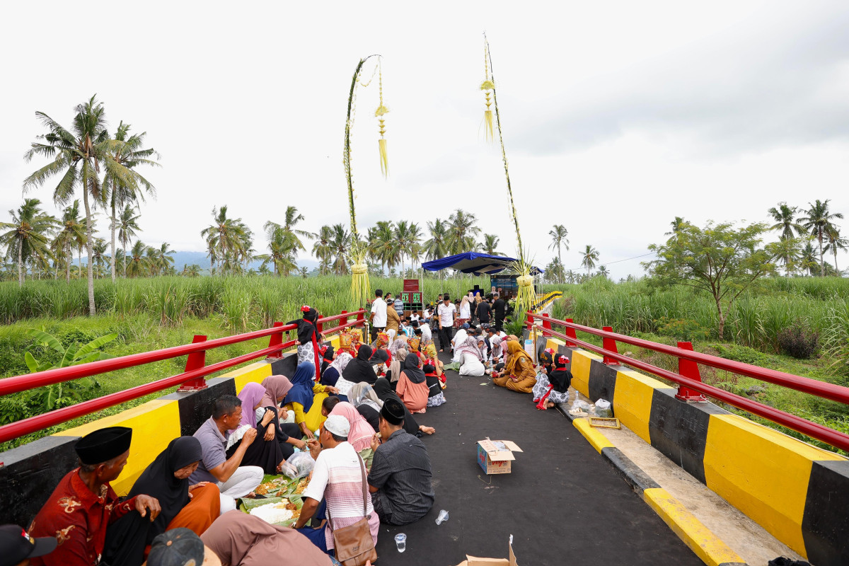 Warga menggelar syukurun diatas jembatan yang yang baru selesai dibangun (foto : istimewa)